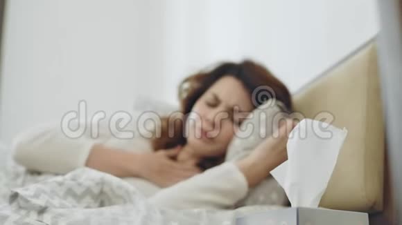 病妇得了咽喉病毒躺在床上特写女性手拿餐巾视频的预览图