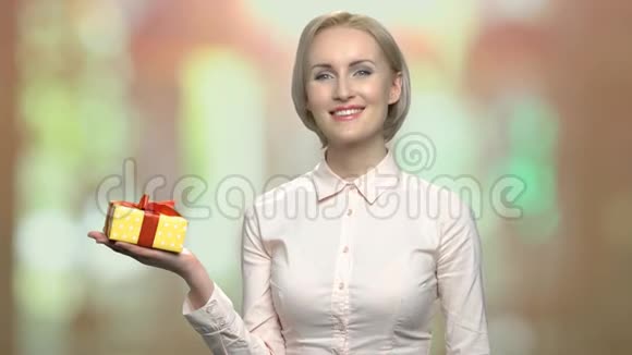 办公室的女人在她的手掌上展示礼物盒视频的预览图