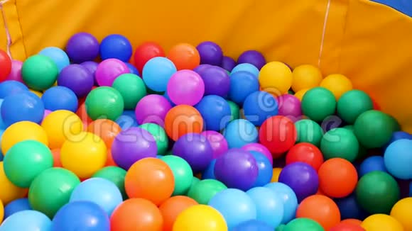 五颜六色的塑料球在游泳池里供儿童使用库存录像把很多彩色球放在操场上视频的预览图