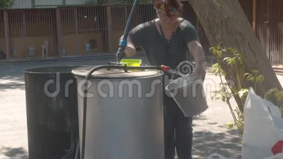 一个女志愿者把水带到水桶里视频的预览图