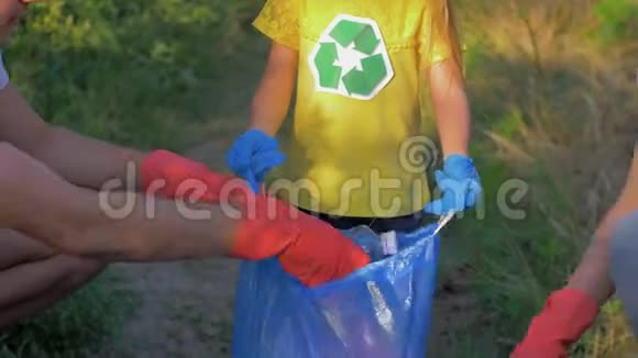 积极分子的孩子帮助爸爸妈妈在清洁塑料和聚乙烯的同时把垃圾收集到垃圾袋里视频的预览图