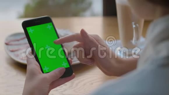 美国纽约2019年5月9日迷人的年轻女人使用她的绿色触摸屏手机在咖啡馆视频的预览图