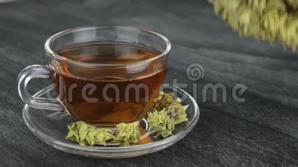 一大堆山茶马洛提拉和杯子与温暖的茶希腊传统草药木制b杯透明杯希腊山茶视频的预览图