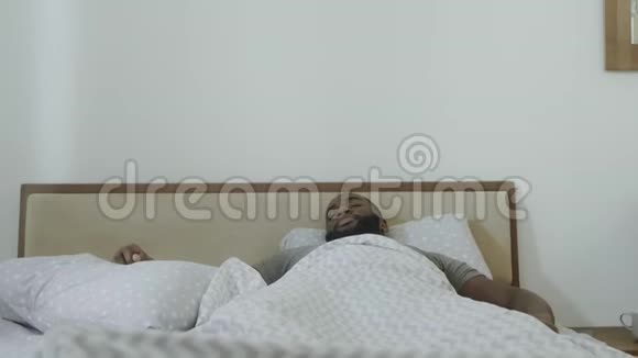 年轻人早上在床上伸出手臂黑人在床上跳舞视频的预览图