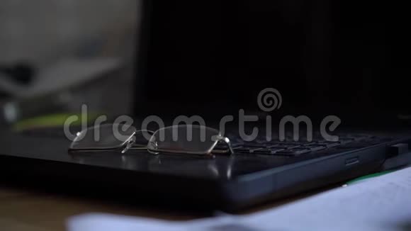 黑色笔记本电脑表面有透明的视力眼镜视频的预览图