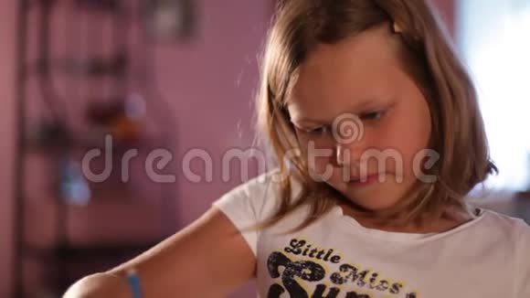 金发小女孩用铅笔画画模糊的背景向上视频的预览图