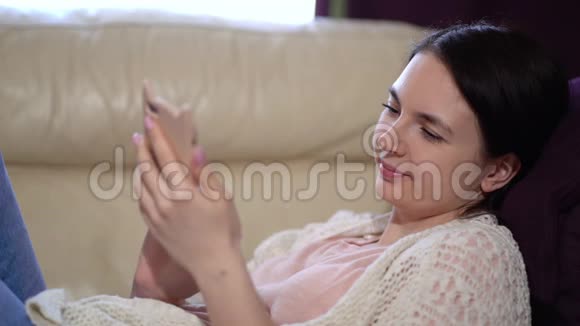 戴口罩的妇女在检疫期间在家使用电话视频的预览图