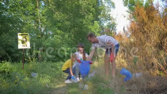 青年幸福家庭志愿者与小女孩一起在垃圾桶中收集垃圾同时从视频的预览图