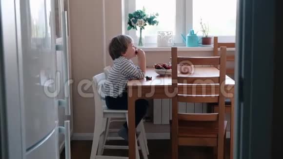 可爱的小男孩在厨房吃草莓关门视频的预览图