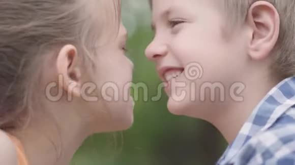 特写一幅可爱的男孩和漂亮的女孩坐在公园里试图擦鼻子玩得开心一对夫妇视频的预览图