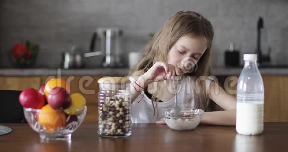 一个没有胃口的悲伤的孩子坐在厨房的桌子旁视频的预览图