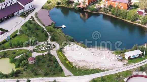 鸟瞰美丽的小村庄小湖或池塘和绿色草坪行动生活观念视频的预览图