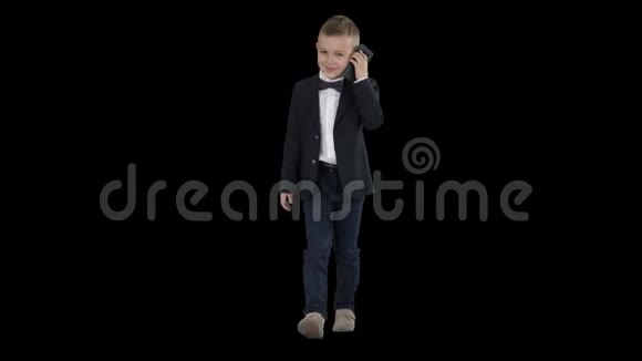 穿着服装的小男孩走路时打电话阿尔法频道视频的预览图