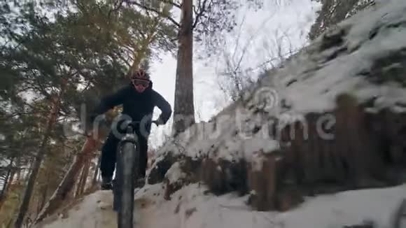 专业的极限运动运动员骑胖自行车在户外风格下坡冬天骑自行车在雪地里视频的预览图