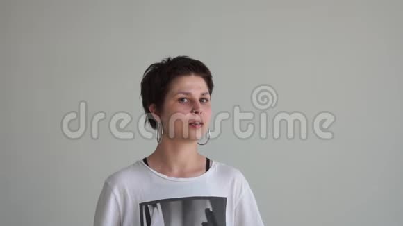 一个穿着刺鼻的女孩坐着惊讶地举起双手在斯洛文尼亚的一个工作室里视频的预览图
