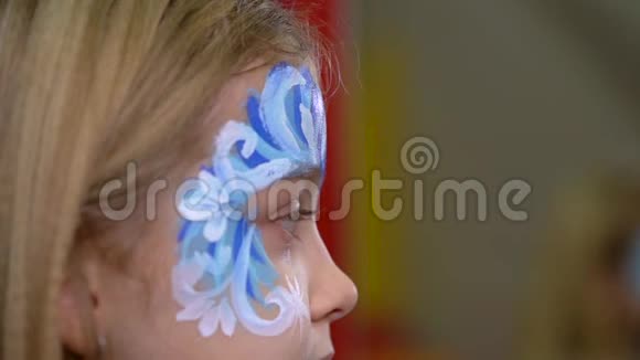 艺术家的手粘着莱茵石在孩子脸上特写镜头视频的预览图
