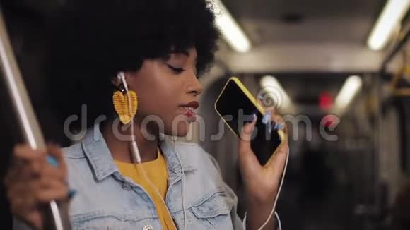 美国黑人少女戴耳机在公共交通中听音乐唱歌和跳舞的肖像视频的预览图