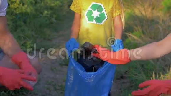 防止污染儿童义工协助家长在清洁塑料及其他垃圾时将垃圾收集在垃圾袋内视频的预览图