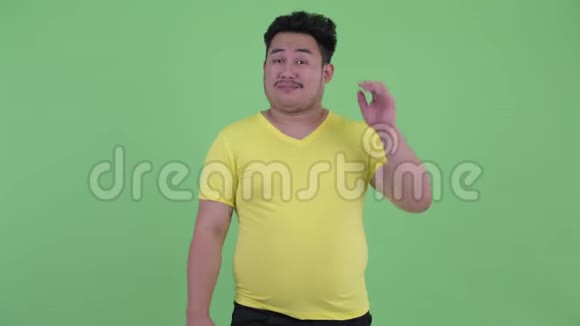 困惑的年轻超重的亚洲男人挠头耸肩视频的预览图