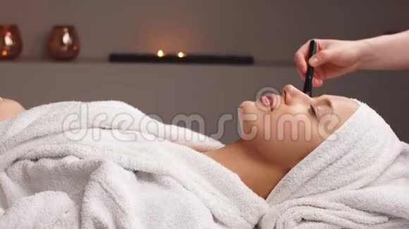 专业美容师在美容院将化妆面膜敷于女性面部视频的预览图