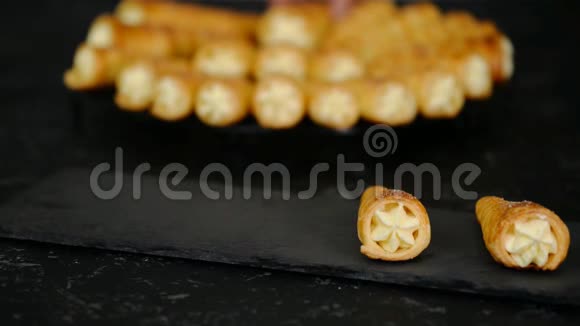 法式奶油角深色背景上有奶油的松饼卷视频的预览图