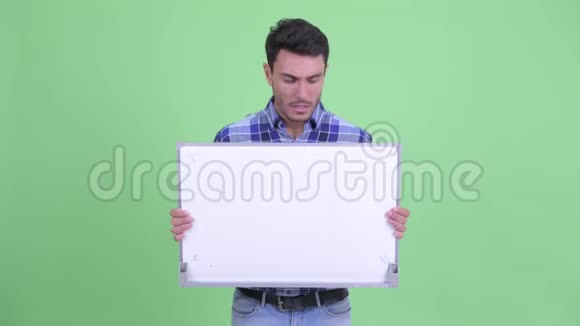 穿着年轻的西班牙裔男子拿着白板得到坏消息视频的预览图
