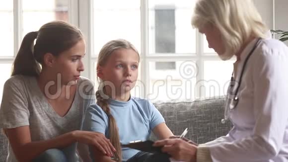 女医生儿科医生与女孩子交谈做笔记视频的预览图