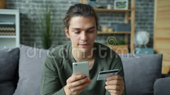 年轻人用银行卡触摸智能手机屏幕在线支付视频的预览图