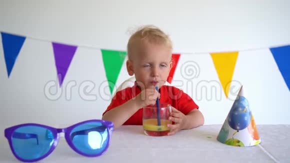 独自蹒跚学步的男孩庆祝他的生日喝橙汁万向节运动视频的预览图