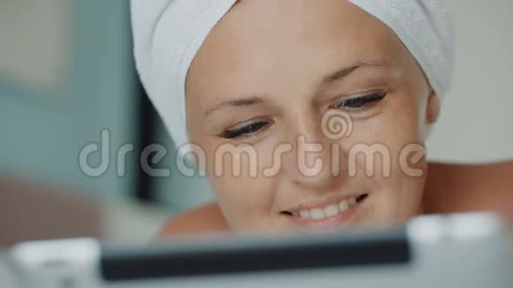 女人在沙发上躺着特写时用浴巾浏览社交媒体的帖子视频的预览图