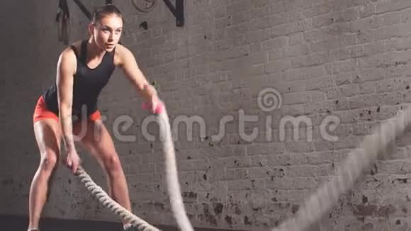 强大的有吸引力的肌肉女人交叉适合教练锻炼与绳索在健身房视频的预览图