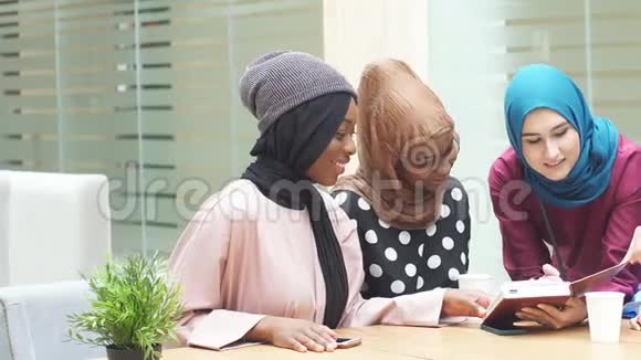 活泼开朗的阿拉伯女学生在咖啡馆看书视频的预览图