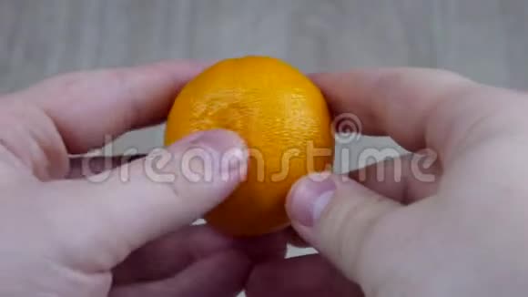 一个男人在木制背景上清洗一种多汁的橘子视频的预览图