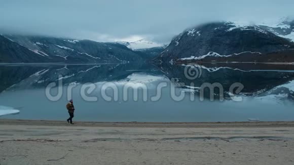 游客背着背包晚上在岸边漫步山景视频的预览图