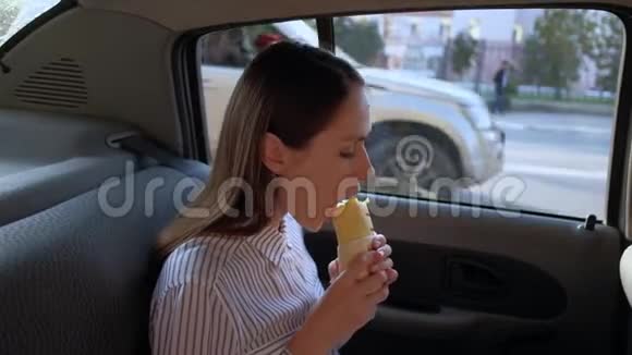 可爱的黑发女人在出租车里吃三明治视频的预览图
