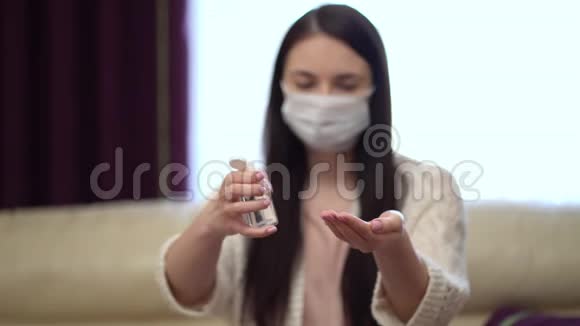 隔离期间使用液体洗手液保护面罩的年轻女性视频的预览图