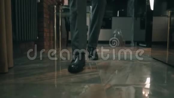 商人穿着漂亮的时髦鞋子和灰色裤子在办公室或房间里散步特写镜头向前看风格视频的预览图