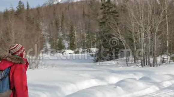 带蓝色和灰色背包的游客沿着雪道散步视频的预览图