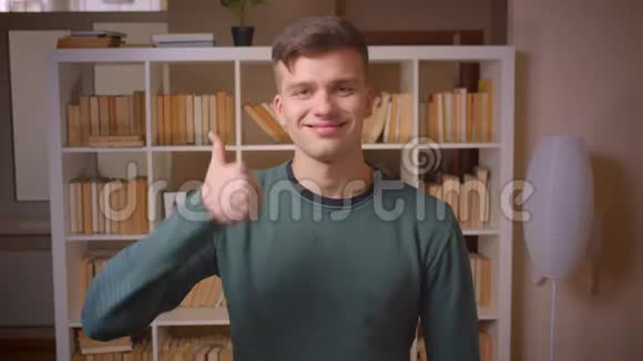 年轻男学生手势的肖像以显示同意和接受在图书馆视频的预览图