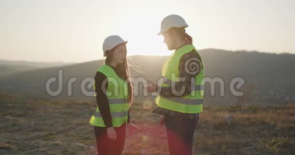 年轻女子微笑时握手时男建筑工人穿着工作服两个工程师握手视频的预览图