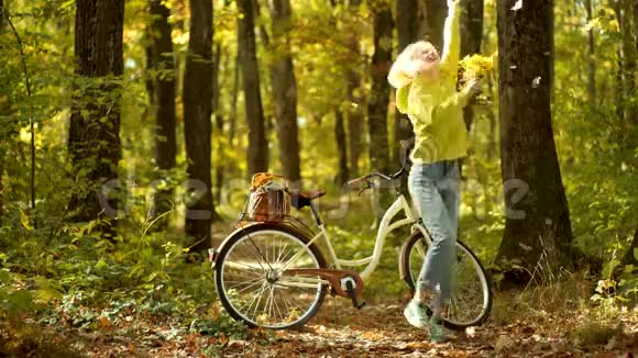 秋天和树叶飘落的梦想秋天的女人穿着秋装落叶笼罩着大自然的背景假期户外度假视频的预览图