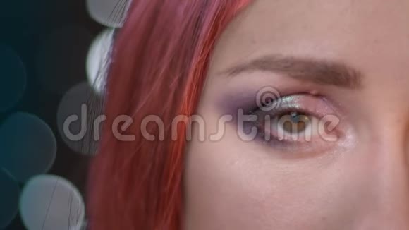 特写半张脸的照片年轻迷人的女性染红头发看着镜头视频的预览图