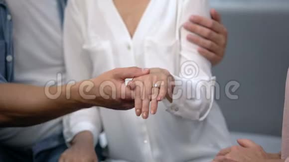 男人用订婚戒指牵着未婚妻的手向母亲展示幸福的家庭视频的预览图