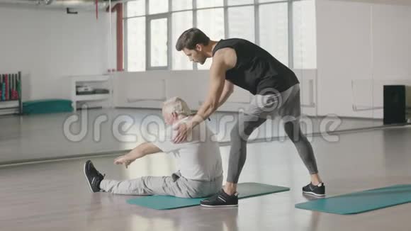 健身教练在体育俱乐部里为老人服务视频的预览图