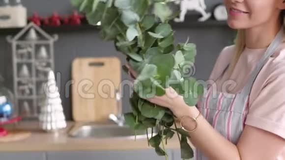 快乐的女人做了一束用来摆桌子的花束金发女郎正在做一束桉树节日餐桌设置视频的预览图