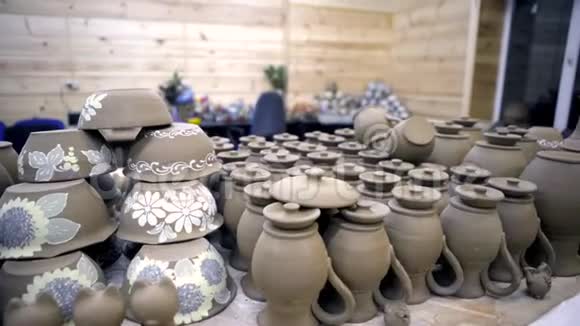 很多自制的陶器库存录像车间桌子上有许多相同的罐子和盘子的灰色陶器视频的预览图