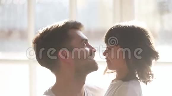 可爱的女儿和快乐的慈爱的父亲拥抱着摸鼻子视频的预览图
