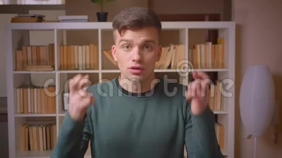 年轻男学生手势的肖像交叉手指在图书馆祈祷成功视频的预览图