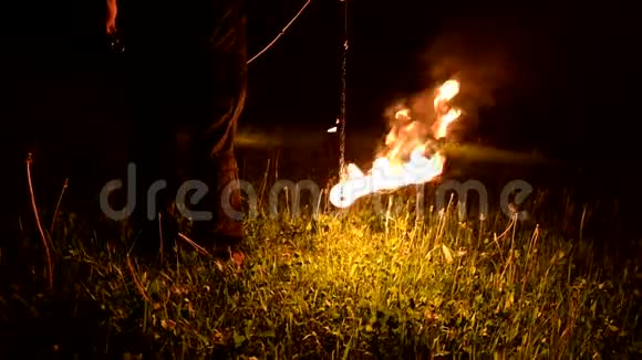 特写镜头镜头跟随黑暗中的人带着燃烧的球波消防表演视频的预览图
