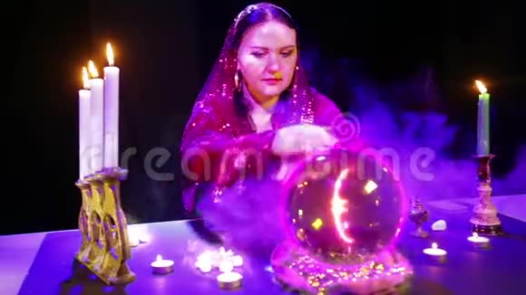 一个吉普赛女人在一个魔法沙龙里在一个水晶球和一个欧元符号上猜测视频的预览图